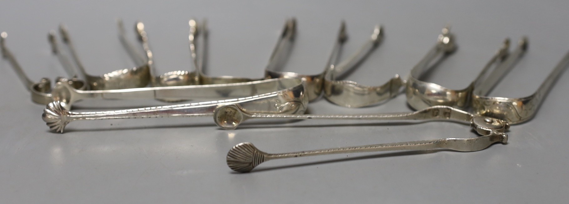 Ten assorted late 18th/early 19th century pairs of silver sugar tongs, various patterns, dates and makers, including two fire tong design, one hallmarked for Newcastle, 10.5oz.